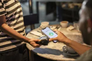 Digital wallet contactless phone payment being used to pay for coffee